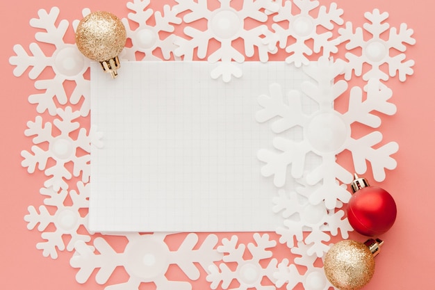 Concepto de año nuevo Lista de objetivos en el bloc de notas, caja de regalo y decoración navideña en color rosa pastel con espacio de copia