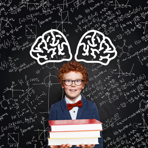 Foto concepto de aprendizaje de ciencias niño inteligente y feliz estudiante en el fondo de la pizarra