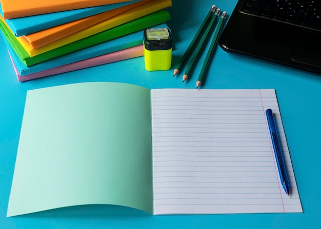 Concepto de aprendizaje a distancia Pila de libros cuaderno lápiz teléfono móvil Escritorio del estudiante sobre aprendizaje en línea