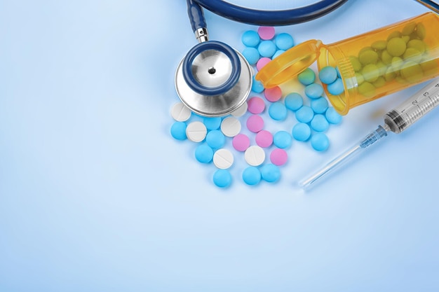 Concepto de atención médica Composición con pastillas y material médico sobre fondo azul.
