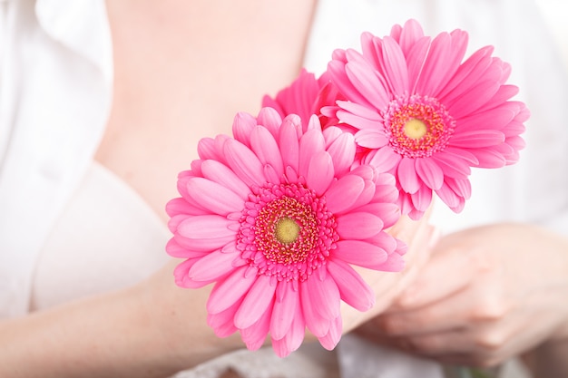 Concepto de atención médica femenina, flor rosa gerbera en mano