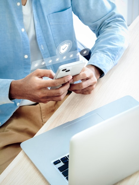 Foto concepto de autenticación de dos factores ícono de escudo de seguridad virtual mientras se accede por teléfono con una computadora portátil para validar la contraseña ciberseguridad de verificación de identidad con tecnología de autenticación biométrica