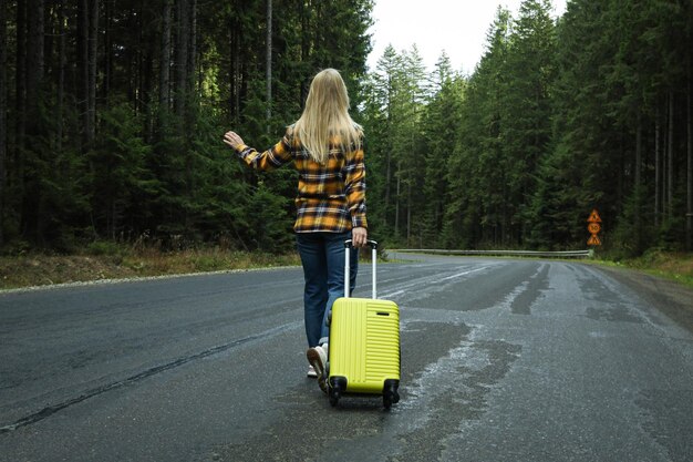 Concepto de aventura y turismo mujer joven que viaja en parada automática