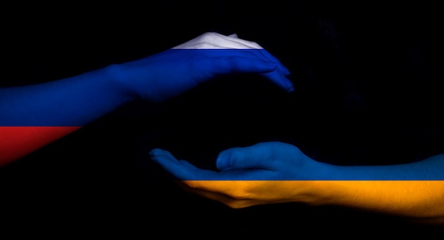 Concepto de bandera de Rusia vs Ucrania Fondo de conflicto militar de crisis de guerra Manos con banderas en foto negra