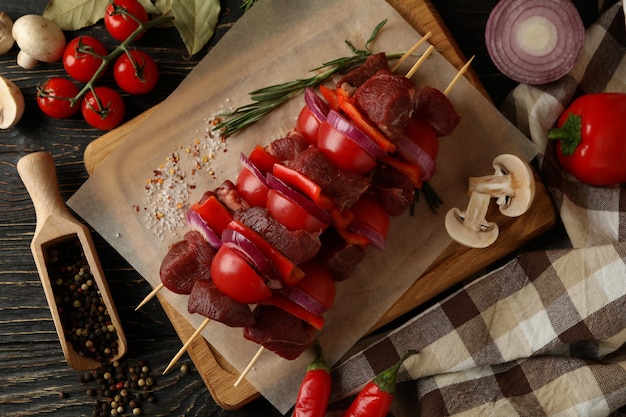 Concepto de barbacoa de cocina con shish kebab crudo e ingredientes en madera