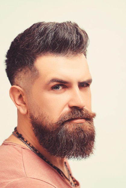 Concepto de barbería Retrato de hombre barbudo brutal severo atractivo tiene un peinado perfecto corte de pelo moderno y elegante