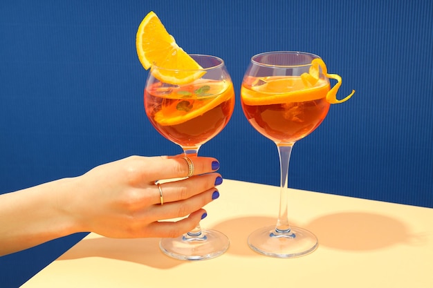 Concepto de bebida alcohólica de verano mano femenina sostiene Aperol Spritz