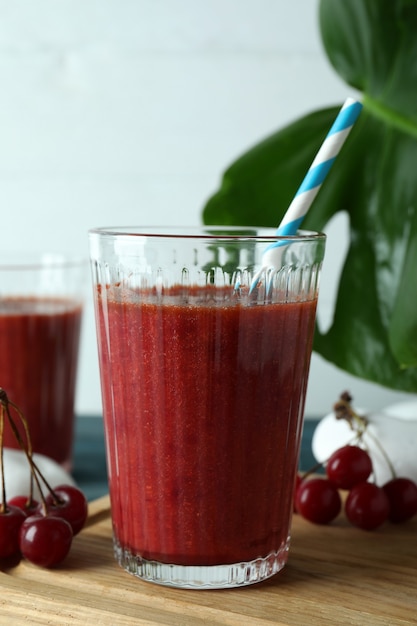 Concepto de bebida dulce con batido de cerezas en mesa de madera