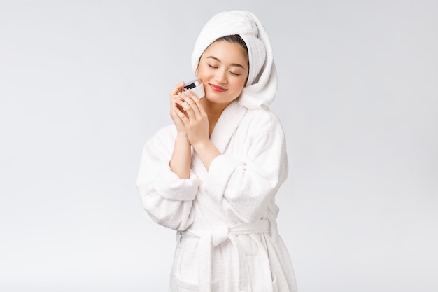 Concepto de belleza mujer bonita asiática con piel perfecta con botella de cosméticos