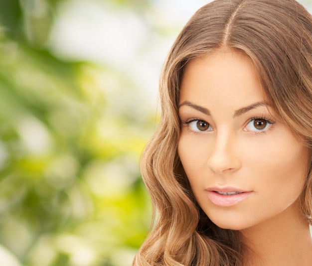 concepto de belleza, personas y salud - hermosa cara de mujer joven sobre fondo verde