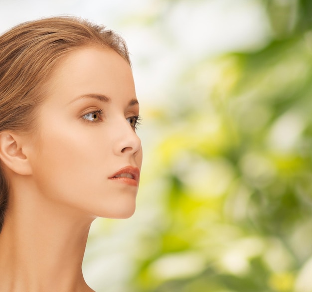 concepto de belleza, personas y salud - hermosa cara de mujer joven sobre fondo verde