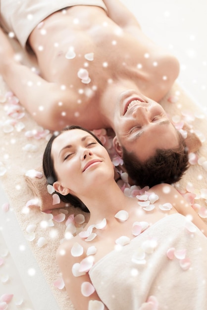 Foto concepto de belleza, salud, vacaciones, gente y spa - pareja feliz con los ojos cerrados en el salón de spa