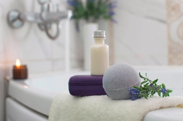 El concepto de belleza Spa. Primer plano de una bola de baño lila con lavanda, una vela aromática en el baño. El concepto de terapia. Tomar un baño relajante Productos de spa para el hogar.