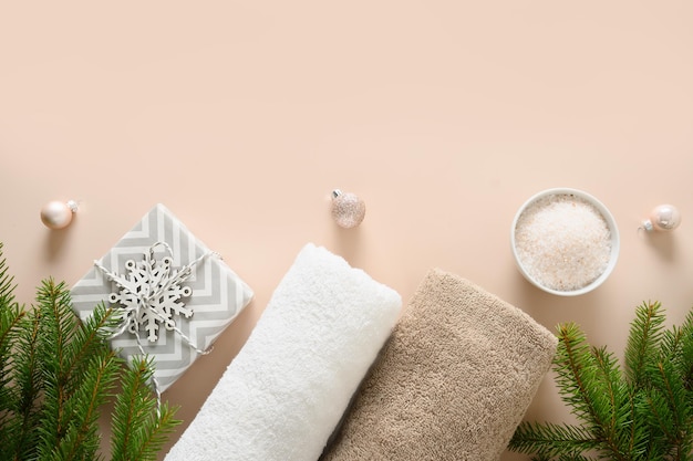 Concepto de bienestar de spa de Navidad con conos de pino de aceite de aroma cosmético sobre fondo beige