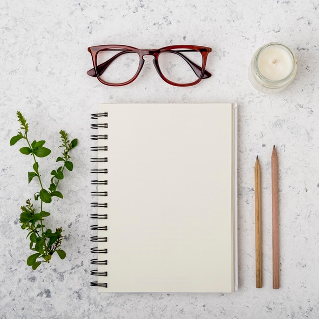 Concepto de bloc de notas con gafas y lápices