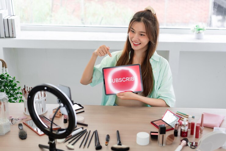 Foto concepto de blogger de belleza la mujer joven señala el texto de suscripción mientras revisa los cosméticos en vlog