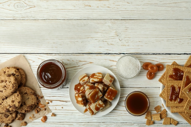 Concepto de bocadillo sabroso con galletas con caramelo en la mesa de madera blanca