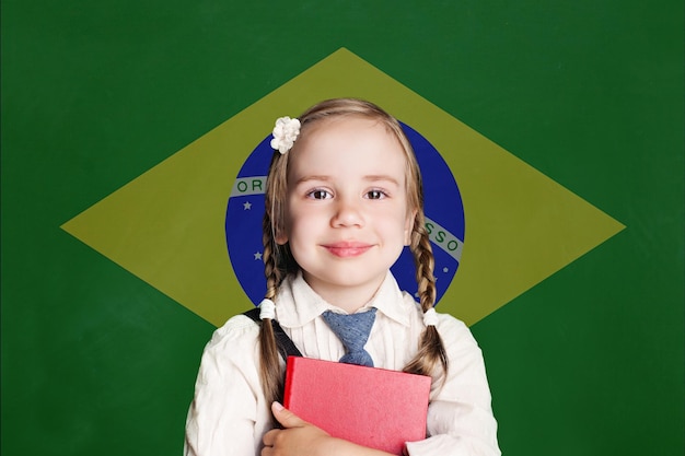 Concepto de Brasil con una estudiante sonriente con un libro en la bandera