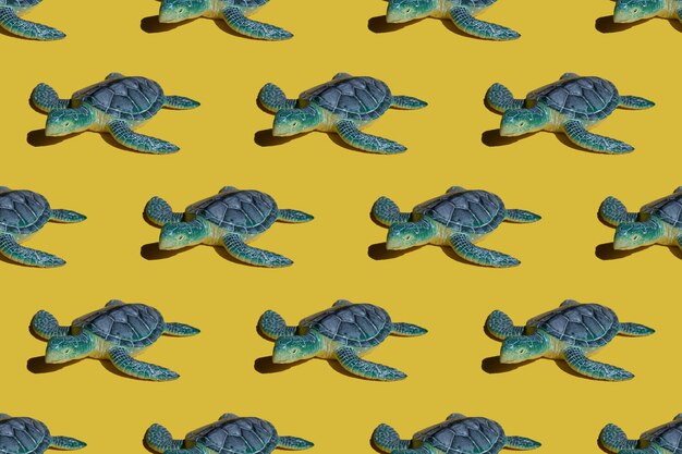 Concepto brillante de verano - tortuga azul sobre un fondo amarillo. Patrón brillante sin costuras