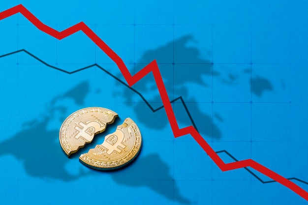 Foto concepto de caída y caída del curso de criptomonedas y prohibición del comercio. moneda bitcoin se divide por la mitad en un azul