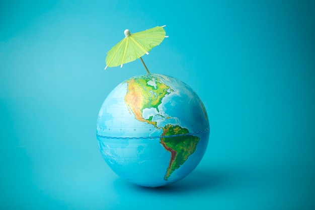 Concepto de calentamiento global y cambio climático en la tierra. Globo terráqueo con un paraguas. Proteger la atmósfera de la radiación ultravioleta y los agujeros de ozono.