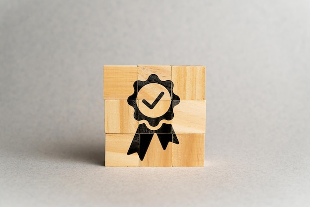 El concepto de calidad y estándares Icono con un cartel en cubos de madera
