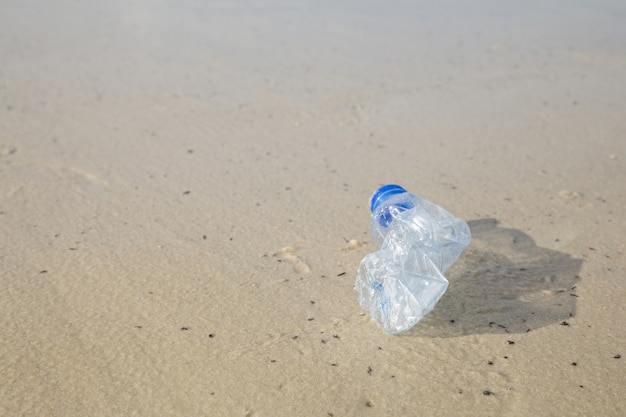 Concepto de campaña ambiental. Botella plástica en la playa.