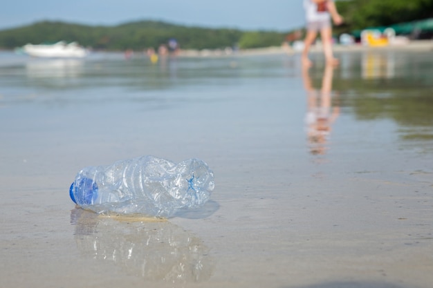 Concepto de campaña ambiental. Botella plástica en la playa.