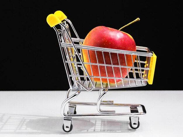 Concepto de carro de supermercado de comer sano manzana roja