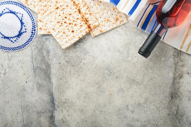 Concepto de celebración de Pascua Matzá rojo kosher y nuez Ritual tradicional pan judío matzá kipá y talit sobre fondo de hormigón antiguo Comida de Pascua Pesaj Fiesta judía