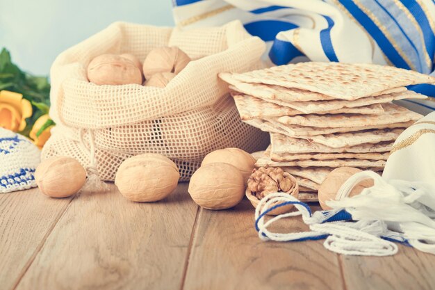 Concepto de celebración de Pascua Matzá rojo kosher y nuez Ritual tradicional Pan judío matzá kipá y talit sobre fondo de madera vieja Comida de Pascua Pesaj Fiesta judía Imagen tonificada