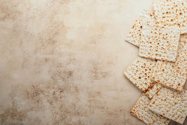 Concepto de celebración de Pascua Matzá rojo kosher y nuez Ritual tradicional Pan judío sobre arena color antiguo fondo de hormigón Comida de Pascua Pesaj Fiesta judía