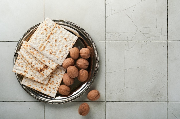 Concepto de celebración de Pascua Matzah rojo nuez kosher Ritual tradicional Judío pan sobre fondo de mesa de encimera de azulejo agrietado gris antiguo Comida de Pascua Fiesta judía de Pesaj