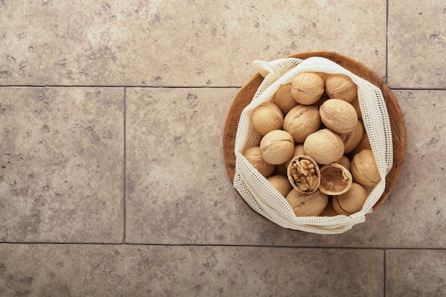 Concepto de celebración de la Pascua Nueces orgánicas en bolsas ecológicas en el fondo de la mesa de la encimera de azulejos grises agrietados antiguos Comida de Pascua Pesaj Fiesta judía Cero desperdicio Vista superior endecha plana Mock up