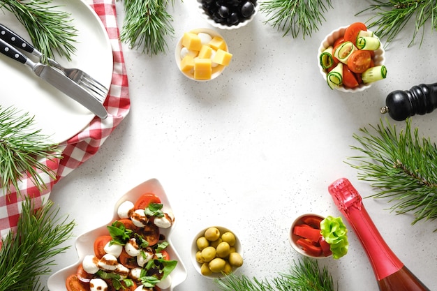 Concepto de cena de Navidad con ensalada Caprese y varios platos de verduras.