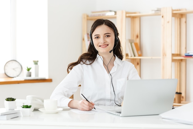 Concepto de centro de llamadas: Retrato de operador de telefonía de atención al cliente sonriente feliz en el lugar de trabajo.