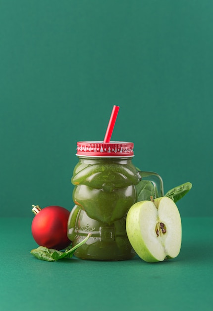 Concepto de cero residuos. Batido de espinacas de manzana verde sobre fondo verde en tarro de cristal de santa claus. Concepto de comida sana y dietética