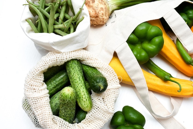 Foto concepto de cero residuos verduras frescas pepinos judías verdes en bolsas ecológicas blancas