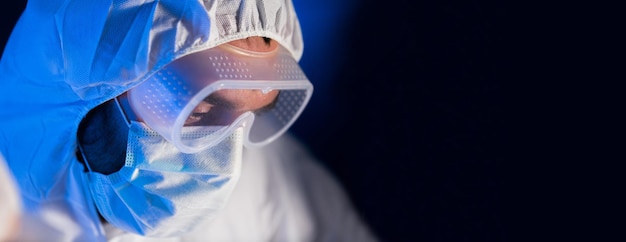 concepto de ciencia, química, biología, medicina y personas - cierre de la cara científica en gafas y máscara protectora en el laboratorio químico sobre fondo oscuro