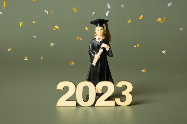 Concepto de clase de 2023 Número de madera 2023 con estatuilla graduada con oropel festivo