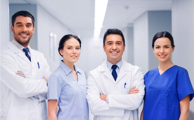 Foto concepto de clínica, profesión, personas, atención médica y medicina - feliz grupo de médicos o médicos en el pasillo del hospital