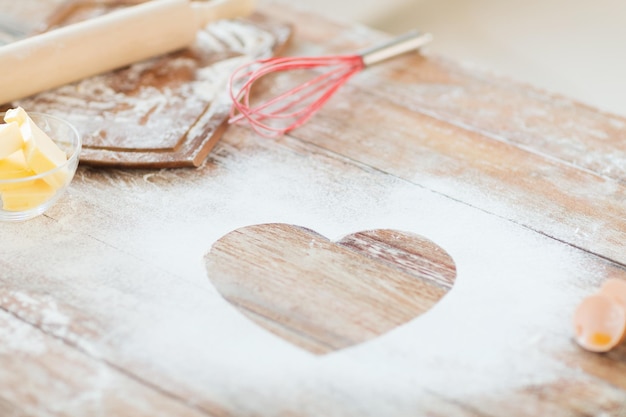 concepto de cocina y amor - cierre del corazón de la harina en la mesa de madera en casa