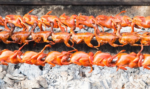 concepto de cocina, cocina asiática, venta y comida - parrilla de codorniz en el mercado callejero