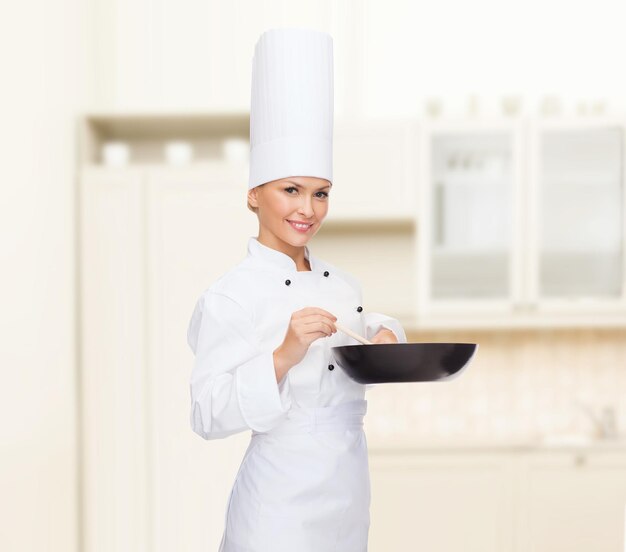 concepto de cocina y comida - chef sonriente con sartén y cuchara