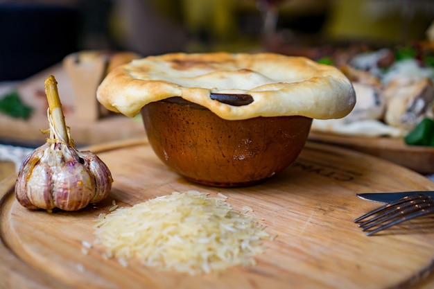 El concepto de cocina oriental. Pilaf uzbeko georgiano casero o plov de cordero servido en utensilios de cocina de hierro fundido.