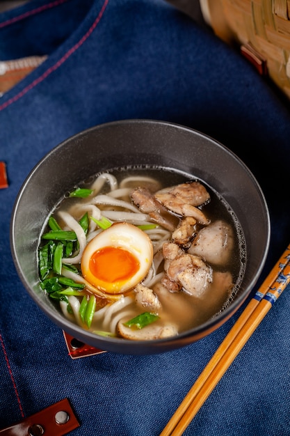 Concepto de cocina panasiática. Sopa japonesa de ramen con fideos chinos, huevo, pollo y cebolla verde. Sirviendo platos en el restaurante en el tazón. Imagen de fondo. copia espacio