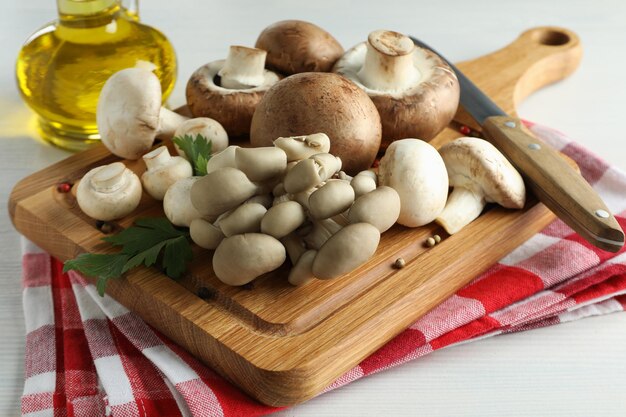 Concepto de cocinar con champiñones en madera blanca