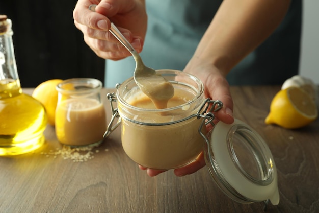 Concepto de cocinar comida sabrosa con salsa tahini en mesa de madera