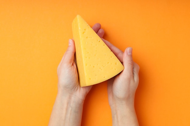 Concepto de cocinar comiendo con queso duro sobre fondo naranja