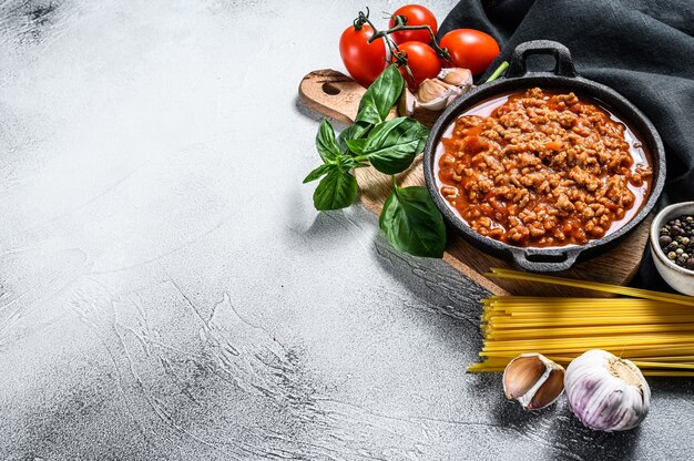 El concepto de cocinar espaguetis a la boloñesa de pasta con tomate, queso y albahaca